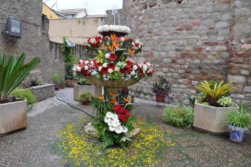 Pati a Ripollet amb una font decorada amb flors per la celebració del Corpus Christi, espai emblemàtic per visitar al municipi
