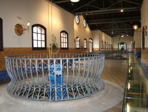Interior de la Casa de les Aigües de Montcada i Reixac amb canonades i mecanismes hidràulics històrics.