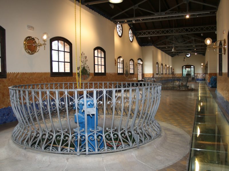 Interior de la Casa de les Aigües de Montcada i Reixac amb canonades i mecanismes hidràulics històrics.