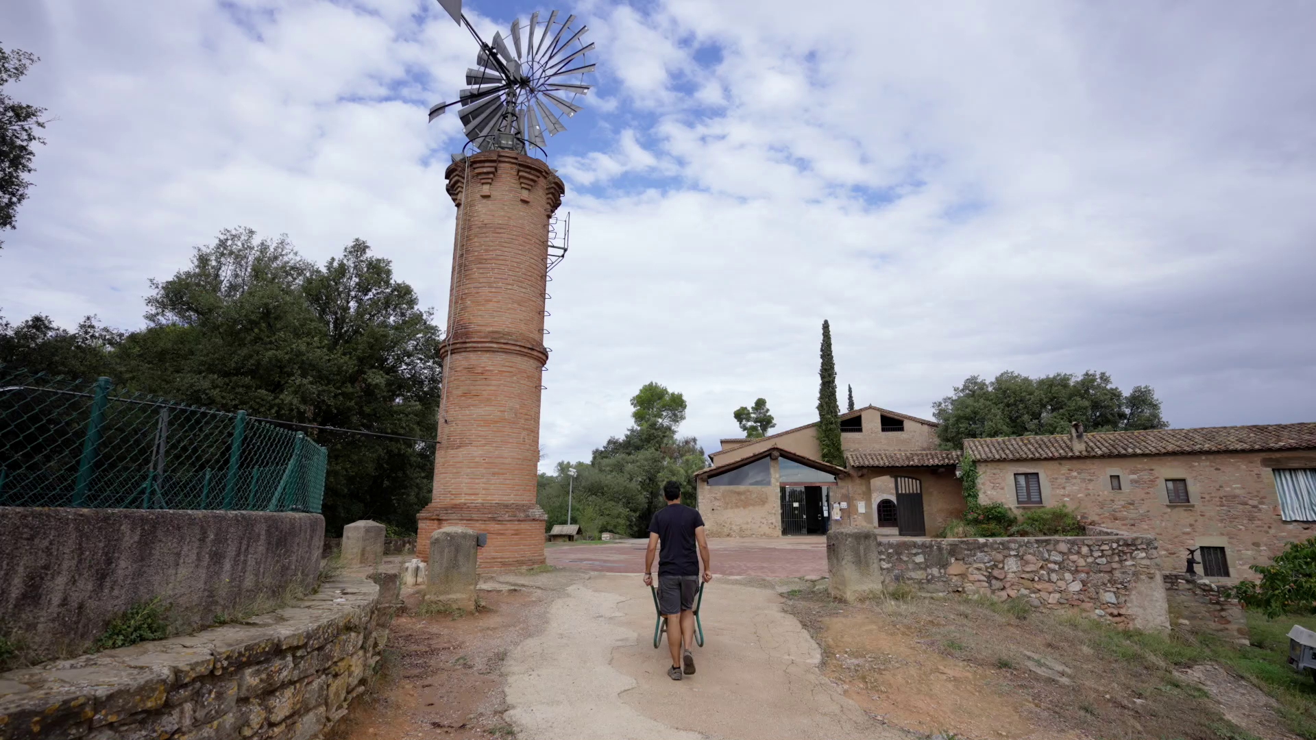 Entrada a la Masia de Can Deu a Sabadell, amb l’antic molí de vent a l’esquerra i la masia al fons